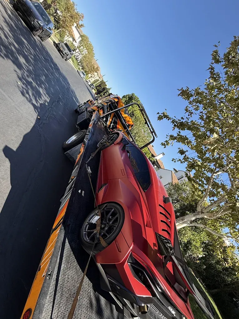 Red sports car on an Urgent Towing flatbed