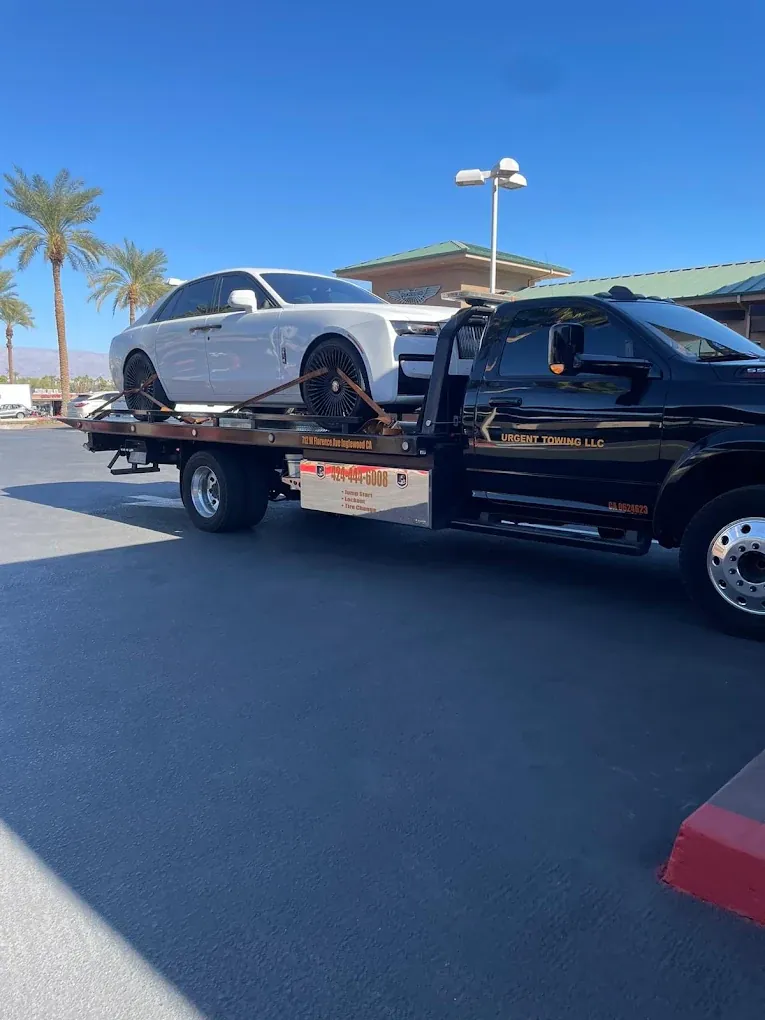 Black Urgent Towing Ram truck in a parking lot