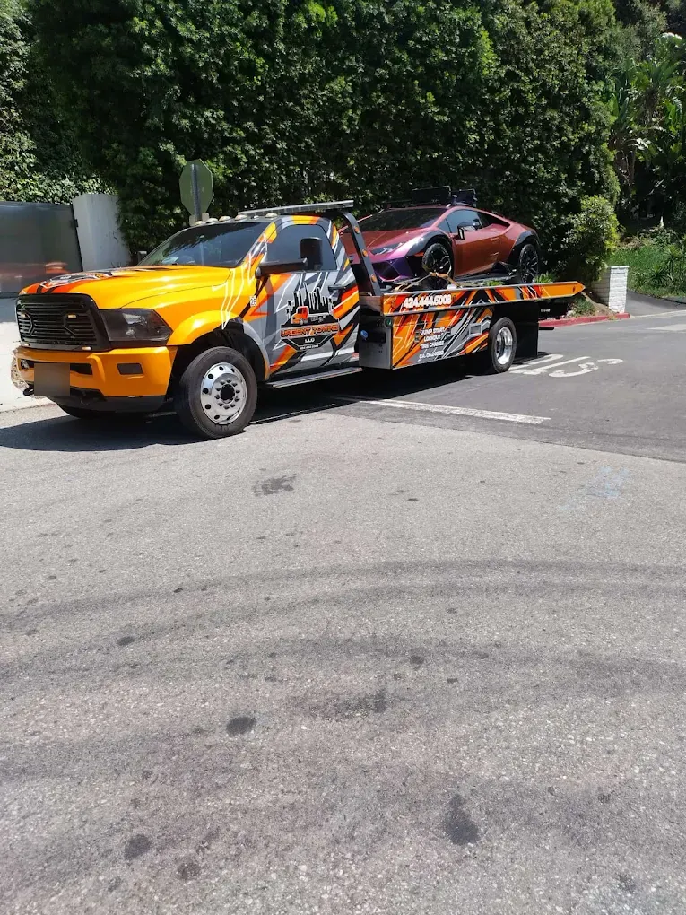 Orange Urgent Towing Ram truck on a street