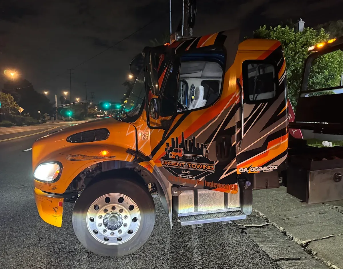 Orange Urgent Towing truck at night with Inglewood, CA on the door