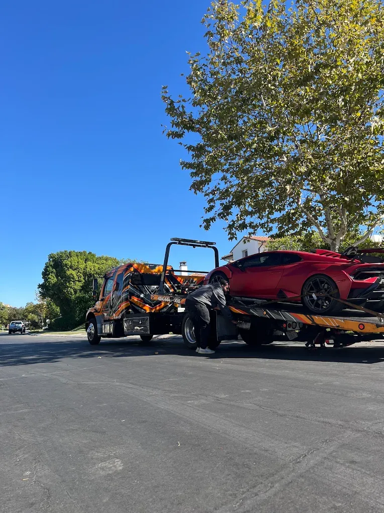 Urgent Towing operator working at the truck on a sunny street