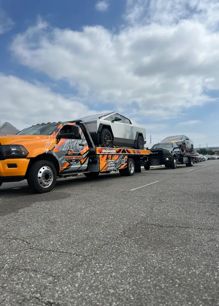 Orange Urgent Towing flatbed carrying a Tesla Cybertruck